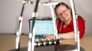 Dr. Christin David presents an experiment in the transfer of mechanical impulse.