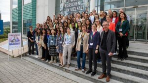 Attendees and hosts of the 2025 Women in Photonics workshop pose for a group photo.